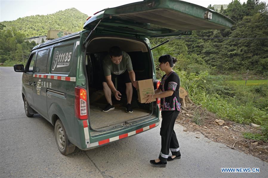 Shi Qiushi (derecha), maestra de escuela primaria, lleva jengibre al vehículo de entrega en la ciudad de Longcheng del condado autónomo Dong de Tongdao, provincia de Hunan, en el centro de China, el 28 de agosto de 2019.