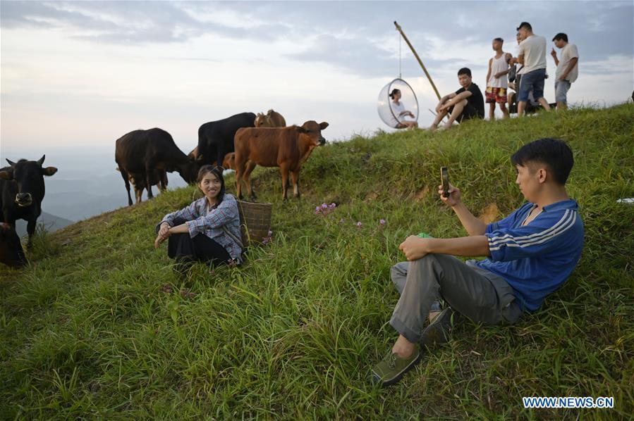 Yang Xiuqian (derecha, frente) graba videos en un pastizal de montaña en la ciudad de Shuangjiang del condado autónomo Dong de Tongdao, en la provincia central china de Hunan, el 28 de agosto de 2019.