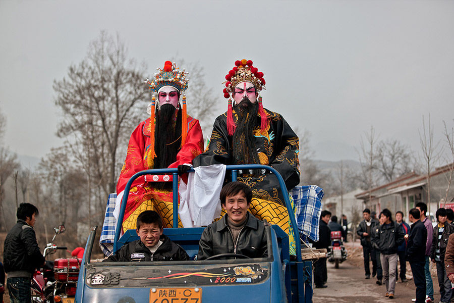 Los actores de Shehuo en un vehículo. [Foto: Wu Xiaopeng/cpanet.org.cn]