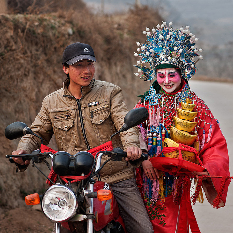 Un actor de Shehuo se baja de una moto. [Foto: Wu Xiaopeng/cpanet.org.cn]
