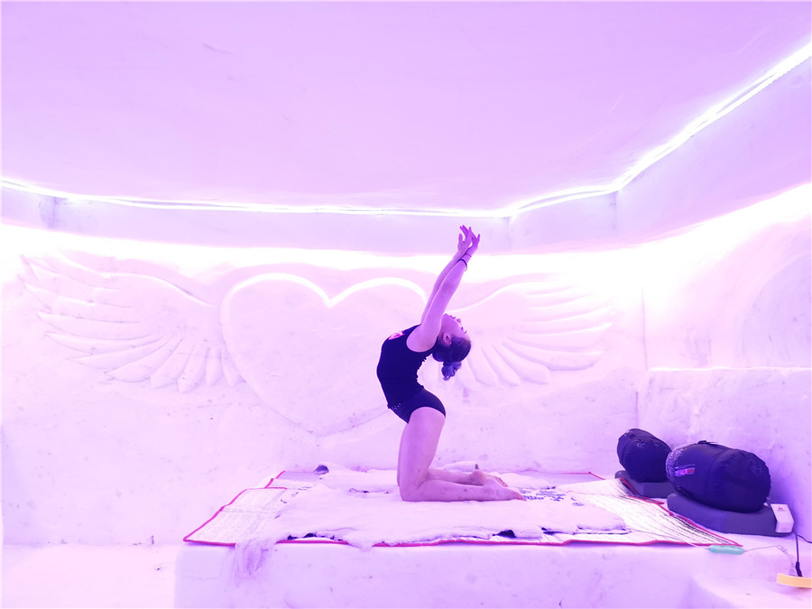 Una entusiasta del yoga practica en la cama de hielo del hotel de hielo y nieve. [Foto: Wang Tieshuang/ Chinadaily.com.cn]