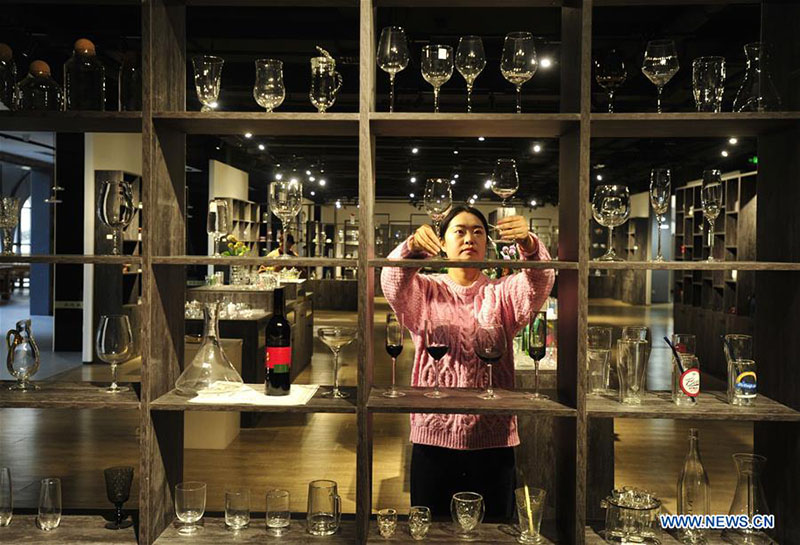 Una trabajadora exhibe copas de vidrio en el Museo del Vidrio en la ciudad de Hejian, provincia de Hebei, en el norte de China, el 18 de diciembre de 2019. 