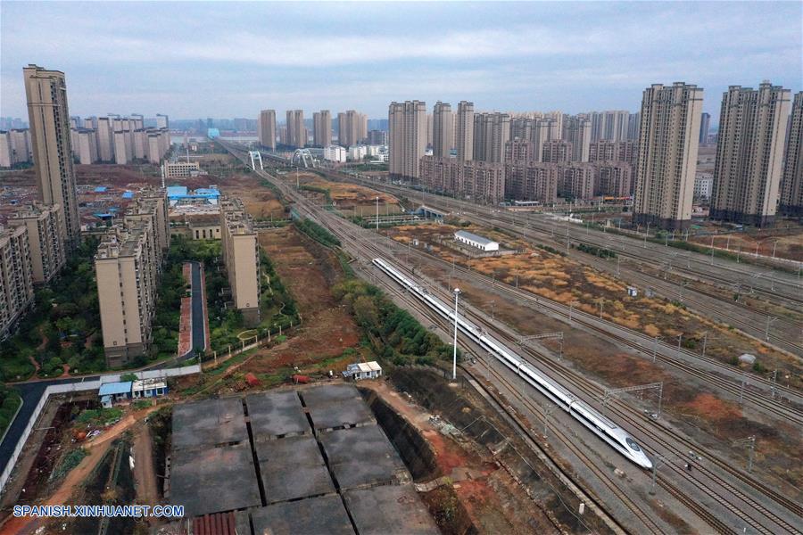 Vista aérea del 26 de diciembre de 2019 del primer tren de alta velocidad G5025 saliendo de la Estación Nanchang Oeste después de la inauguración del ferrocarril de alta velocidad Nanchang-Ganzhou, en Nanchang, capital de la provincia de Jiangxi, en el este de China. Un ferrocarril de alta velocidad inició operaciones el jueves en la provincia china de Jianxi, enlazando la capital provincial Nanchang con la "cuna de la revolución china" Jinggangshan y la zona rica en tierras raras de Ganzhou. La vía de 418 kilómetros de largo está diseñada para una velocidad de 350 km por hora y acorta el antiguo viaje por tren de cuatro horas a menos de dos horas. (Xinhua/Peng Zhaozhi)