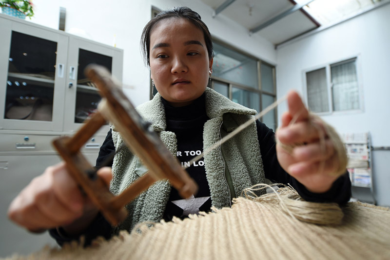 Guo Juan enrolla una cuerda de cáñamo en su fábrica en el condado Gangu, provincia de Gansu, noroeste de China, el 10 de enero de 2020. [Foto / Xinhua]