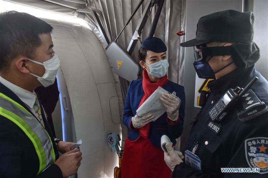 BEIJING, 2 febrero, 2020 (Xinhua) -- Imagen del 1 de febrero de 2020 del policía Wu Shengzao (d), preguntando a empleados de una aerolínea sobre la condición de los pasajeros en el Aeropuerto Internacional Daxing en Beijing, capital de China. Las autoridades chinas han endurecido las medidas para combatir la epidemia del nuevo coronavirus a medida que el número de personas que salen a carretera y regresan a trabajar aumenta después de las vacaciones del Festival de Primavera. Wu Shengzao, de 34 años de edad, es un policía que trabaja en el Aeropuerto Internacional Daxing. Durante la batalla antivirus, Wu y sus colegas pasaron días patrullando el aeropuerto, midiendo la temperatura de los pasajeros y controlando sus condiciones y necesidades. (Xinhua/Peng Ziyang)