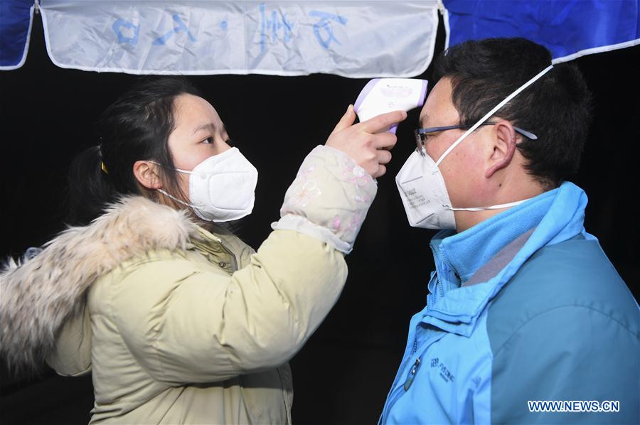 WANZHOU, 31 enero, 2020 (Xinhua) -- Imagen del 30 de enero de 2020 de una trabajadora (i) verificando la temperatura corporal de un transeúnte en un puesto de control en la aldea de Changping de Wanzhou, municipalidad de Chongqing, en el suroeste de China. (Xinhua/Wang Quanchao)