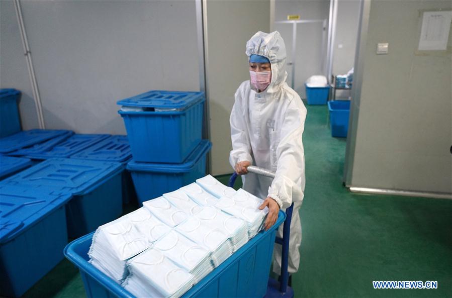 NANCHANG, 2 febrero, 2020 (Xinhua) -- Imagen del 1 de febrero de 2020 de un trabajador trasladando mascarillas en un taller de una compañía en el distrito Jinxian, provincia de Jiangxi, en el este de China. Para ayudar a combatir el brote de neumonía causada por el nuevo coronavirus, los trabajadores de muchas compañías de material médico se apresuraron a trabajar antes de lo previsto. (Xinhua/Wan Xiang)