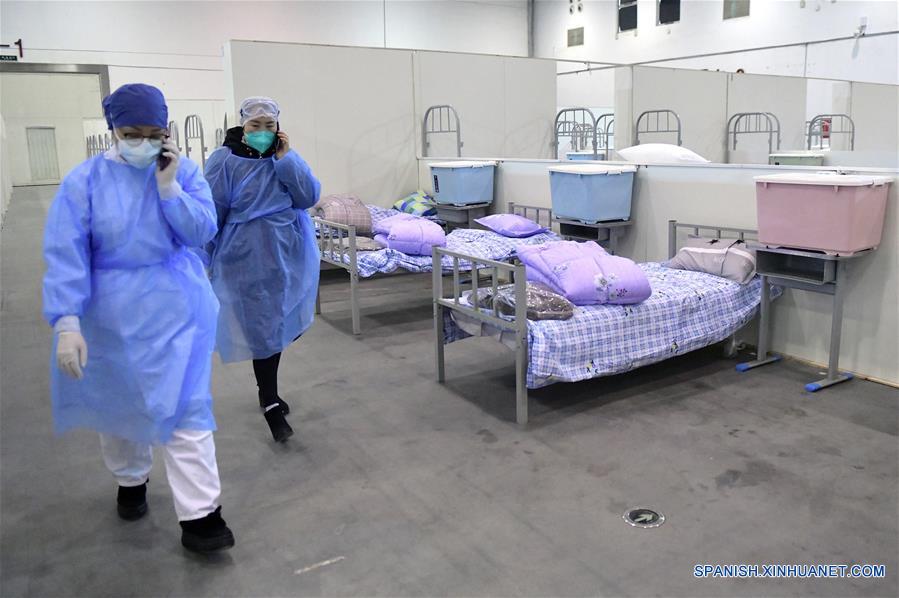 WUHAN, 8 febrero, 2020 (Xinhua) -- Trabajadores médicos pasan por la unidad de enfermería B del "Wuhan Livingroom" en Wuhan, provincia de Hubei, en el centro de China, el 8 de febrero de 2020. El complejo de edificios culturales denominado "Wuhan Livingroom," que se convirtió en hospital para recibir pacientes infectados con el nuevo coronavirus, está diseñado para alojar 2,000 camas. La unidad de enfermería B del hospital está lista, mientras la unidad A se ha puesto en uso antes. (Xinhua/Li He)