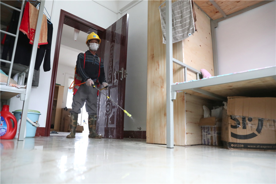 Un hombre desinfecta un dormitorio en una fábrica que se prepara para reanudar el trabajo en Qingdao, provincia de Shandong, 9 de febrero del 2020. [Foto: Xinhua]