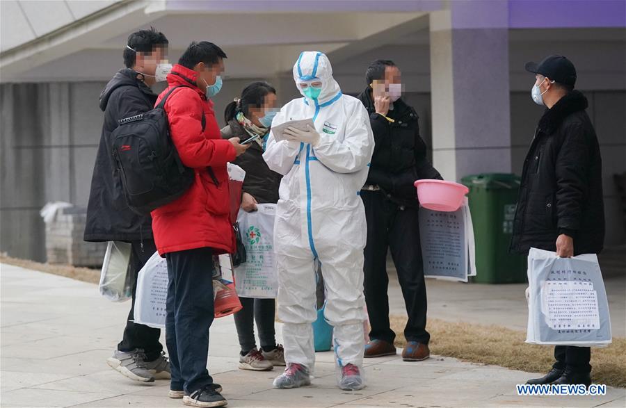 WUHAN, 14 febrero, 2020 (Xinhua) -- Un trabajador médico (3-d) registra la información de los pacientes como parte del trabajo de recepción en el hospital provisional Jiangxia, en Wuhan, ciudad capital de la provincia de Hubei, en el centro de China, el 14 de febrero de 2020. El hospital provisional Jiangxia, un hospital de 400 camas convertido de un centro deportivo al aire libre, comenzó a recibir pacientes con neumonía COVID-19 con síntomas leves el viernes. El hospital es el primer hospital provisional que adoptará principalmente el tratamiento de medicinas tradicionales chinas para curar a los pacientes. (Xinhua/Cheng Min)