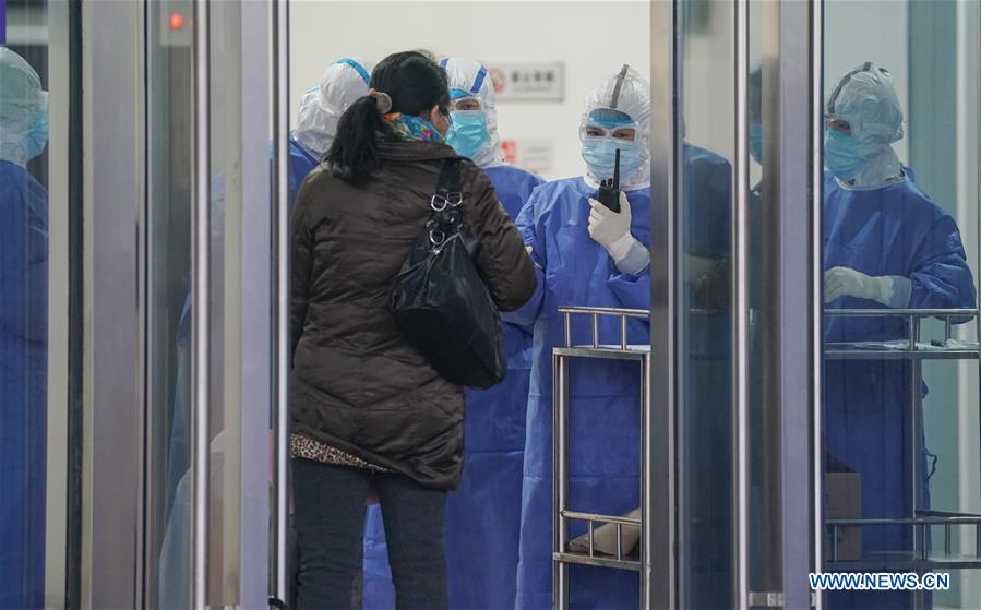 WUHAN, 14 febrero, 2020 (Xinhua) -- Trabajadores médicos guían a una paciente en el hospital provisional Jiangxia, en Wuhan, ciudad capital de la provincia de Hubei, en el centro de China, el 14 de febrero de 2020. El hospital provisional Jiangxia, un hospital de 400 camas convertido de un centro deportivo al aire libre, comenzó a recibir pacientes con neumonía COVID-19 con síntomas leves el viernes. El hospital es el primer hospital provisional que adoptará principalmente el tratamiento de medicinas tradicionales chinas para curar a los pacientes. (Xinhua/Cheng Min)