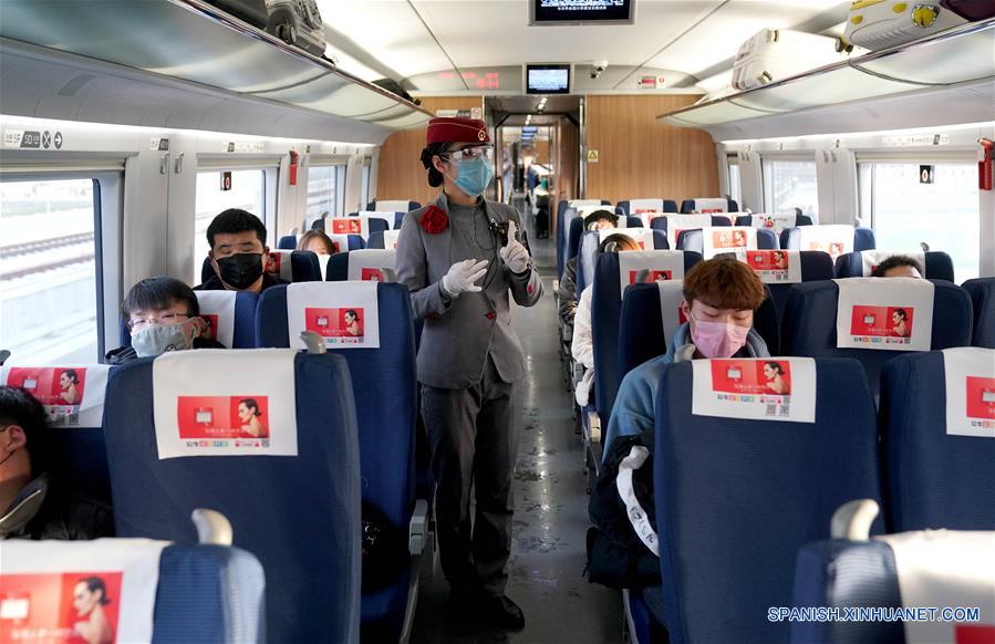 BEIJING, 26 febrero, 2020 (Xinhua) -- Imagen del 22 de febrero de 2020 de una azafata presentando medidas de prevención y control del nuevo coronavirus a los pasajeros en un tren especial que se dirige a la provincia de Zhejiang, en el este de China. (Xinhua/Li An)
