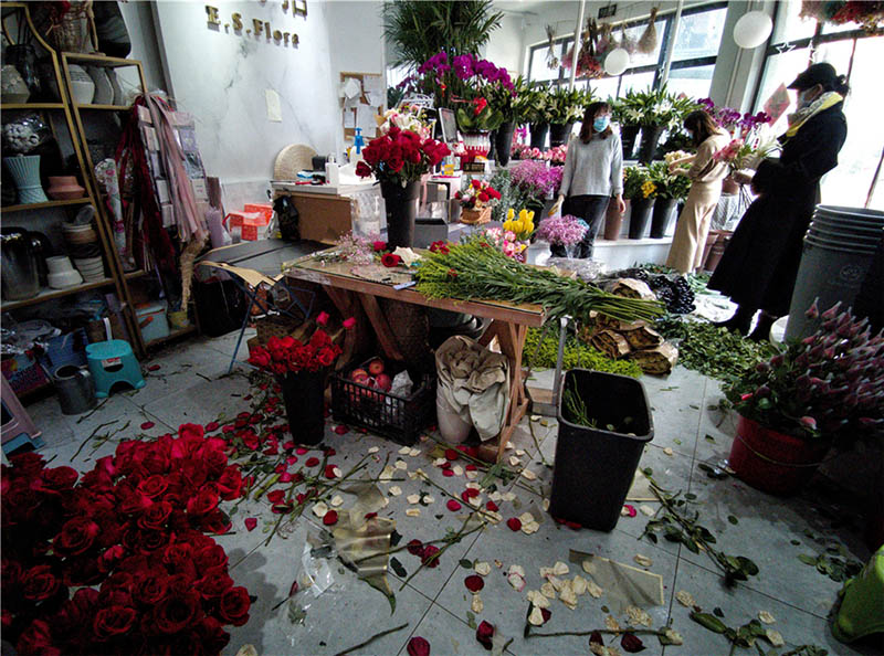 Un empleado de una floristería, cercana a la comunidad donde vive el fotógrafo, prepara adornos florales, 14 de febrero del 2020. [Foto: Qian Han/ China Daily] 