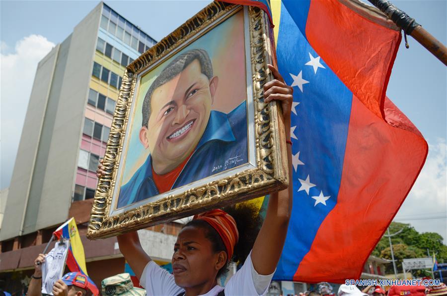 CARACAS, 8 marzo, 2020 (Xinhua) -- Una mujer sostiene un cuadro con la imagen del ex presidente venezolano Hugo Chávez, durante una manifestación por el Día Internacional de la Mujer en Caracas, Venezuela, el 8 de marzo de 2020. (Xinhua/Marcos Salgado)
