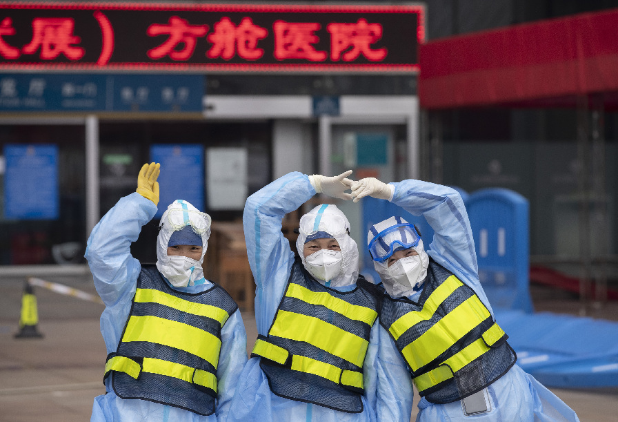 Tres enfermeras posan frente a un hospital temporal recién clausurado, en Wuhan, capital de la provincia central china de Hubei, el 9 de marzo de 2020. (Xinhua/Fei Maohua)