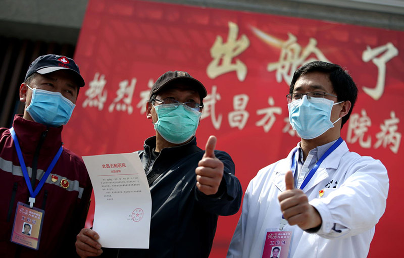 Durante la ceremonia de clausura del Hospital Temporal Wuchang, un paciente recuperado (al centro) agradece a los miembros del personal de la salud. Wuhan, provincia de Hubei, 10 de marzo del 2020. (Foto: Zhang Zheng/ China Daily)