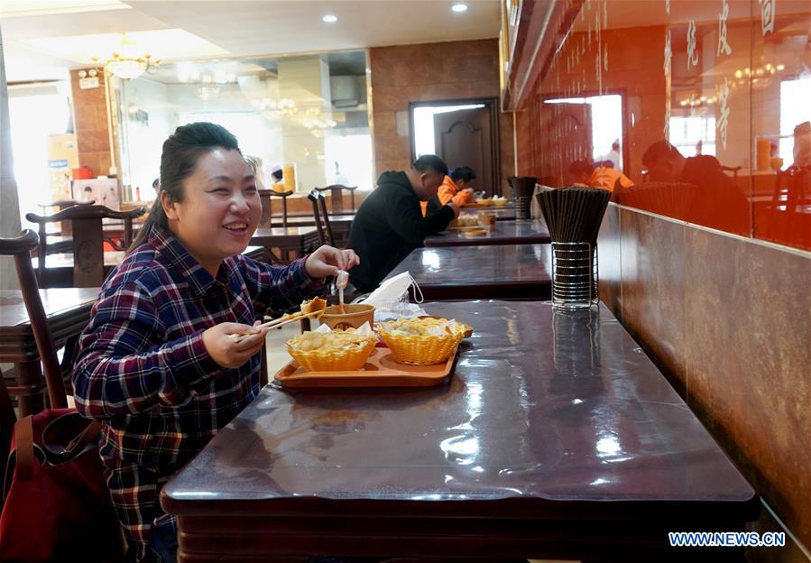 Una mujer come en un restaurante de Zhengzhou, provincia de Henan. 