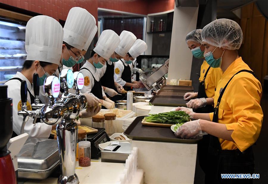 Los trabajadores preparan platos en un restaurante de Zhengzhou, provincia de Henan. 