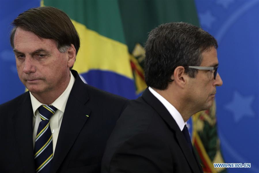 BRASILIA, 27 marzo, 2020 (Xinhua) -- El presidente de Brasil, Jair Bolsonaro (i), y el presidente del Banco Central brasileño, Roberto Campos Neto (d), asisten a una conferencia de prensa para anunciar las medidas económicas para combatir la enfermedad provocada por el nuevo coronavirus (COVID-19), en el Palacio de Planalto, en Brasilia, Brasil, el 27 de marzo de 2020. El gobierno de Brasil anunció el viernes un programa de auxilio a pequeñas y medianas empresas con líneas de financiamiento para el pago de salarios y mantener así el empleo en el sector. El programa ayudará a los ingresos de un porcentaje importante de la fuerza de trabajo durante la fase crítica por la epidemia del nuevo coronavirus. (Xinhua/Lucio Tavora)