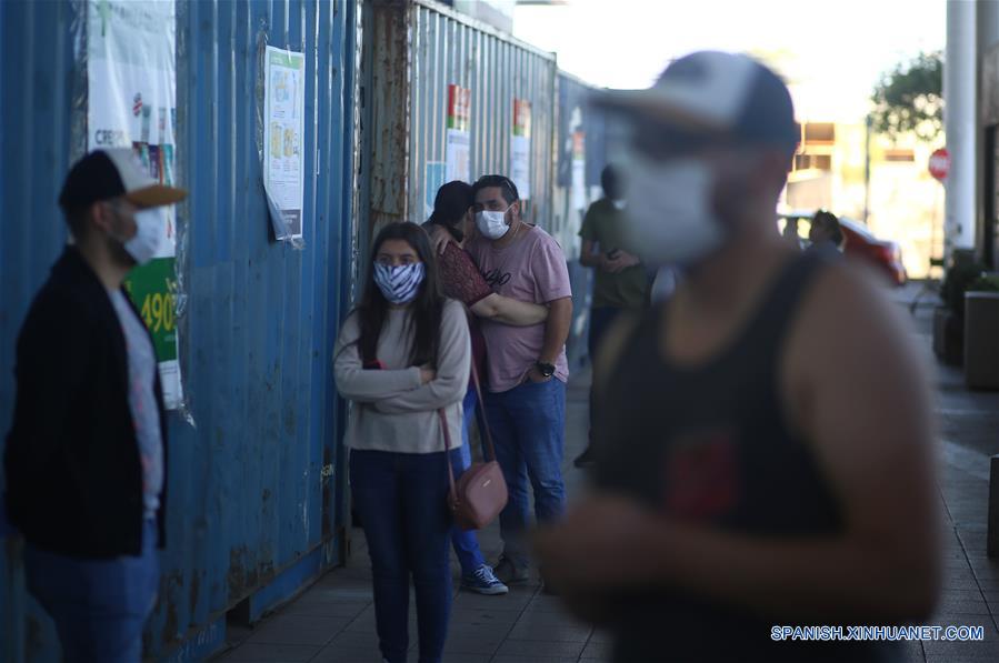 CHILLAN, 29 marzo, 2020 (Xinhua) -- Personas portando mascarillas hacen fila para entrar a un supermercado, en la ciudad de Chillán, en la región de Ñuble, Chile, el 29 de marzo de 2020. El gobierno de Chile informó el domingo que existen 2.139 casos confirmados de la enfermedad causada por el nuevo coronavirus (COVID-19) y siete víctimas mortales de la enfermedad en el país. (Xinhua/Str)
