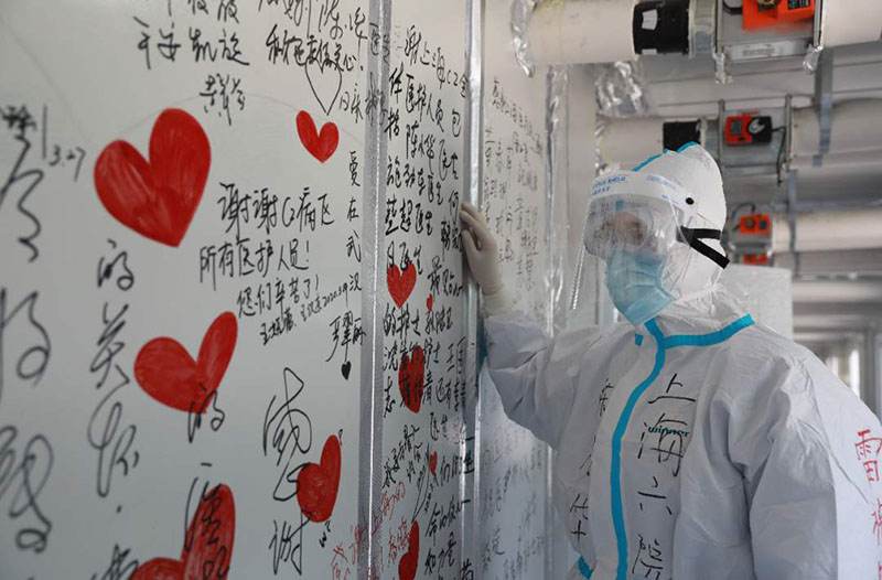 Un trabajador médico de Shanghai mira un tablero con palabras de agradecimiento para el personal médico.