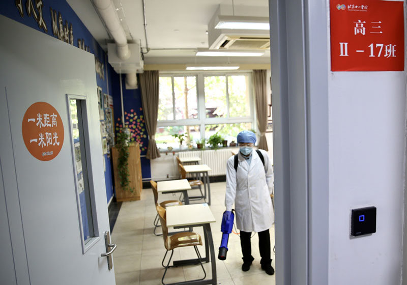 Un empleado de la Escuela del Día Nacional de Beijing desinfecta un aula de tercer curso, el 21 de abril de 2020. [Foto de Zuo Hong / chinadaily.com.cn]