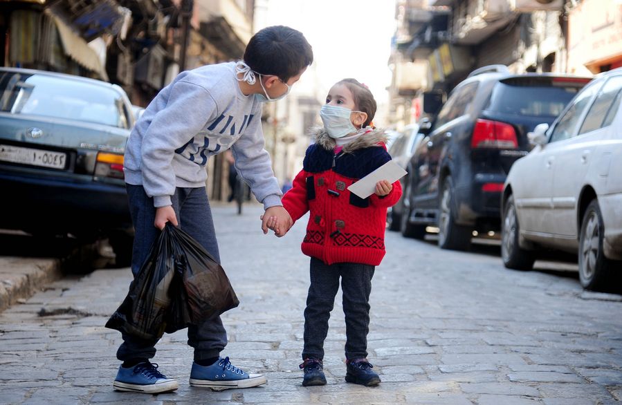 Niños portan mascarillas mientras caminan en una calle, en Damasco, Siria, el 12 de abril de 2020. (Xinhua/Ammar Safarjalani)