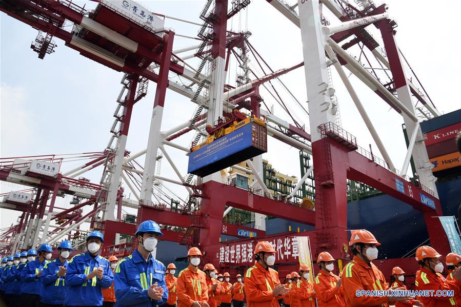 Trabajadores participan en la ceremonia del viaje inaugural del buque HMM Algeciras, en el puerto de Qingdao, en Qingdao, provincia de Shandong, en el este de China, el 26 de abril de 2020. El HMM Algeciras, el buque portacontenedores más grande del mundo con una capacidad de 24.000 TEU (unidad equivalente a 20 pies), comenzó el domingo su primer viaje desde el puerto de Qingdao. (Xinhua/Li Ziheng)