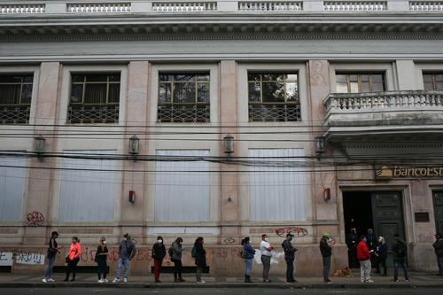 Varias personas hacen fila antes de ingresar a una sucursal bancaria en la ciudad de Chillán de la región de Ñuble, en Chile, el 23 de abril de 2020. (Xinhua/Str)