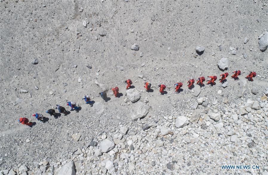 Vista aérea del 2 de mayo de 2020 de Xue Qiangqiang y sus compañeros de equipo partiendo del campamento base del Monte Qomolangma, en la región autónoma del Tíbet, en el suroeste de China. Esta es la primera vez que Xue Qiangqiang, de 37 años, asciende al Monte Qomolangma, el pico más alto del mundo. El es miembro de un equipo chino que volverá a medir la altura de la montaña en mayo. (Xinhua/Sun Fei)