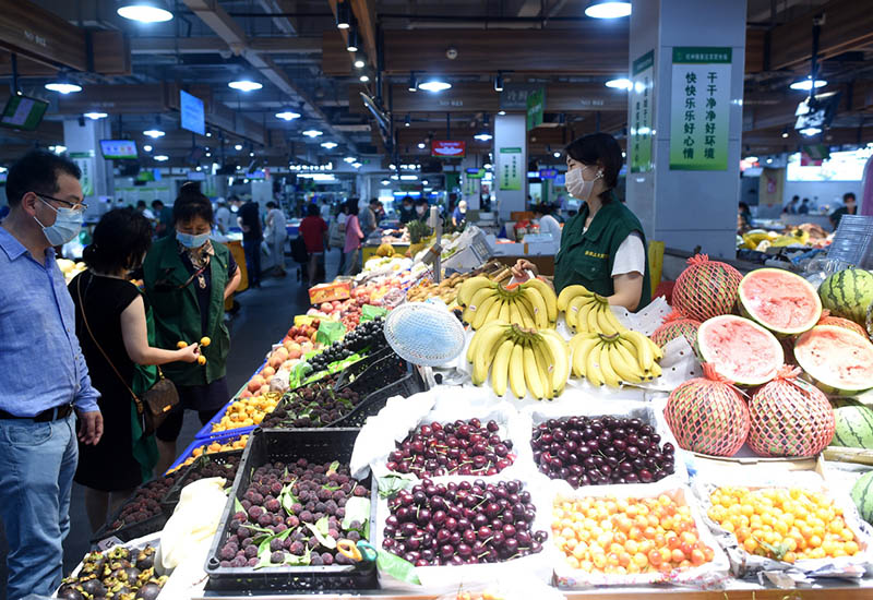 Clientes eligen frutas en el Mercado de Agricultores de Luojiazhuang, en Hangzhou, primer mercado 5G de la provincia de Zhejiang, 17 de mayo del 2020. [Foto: Xinhua]
