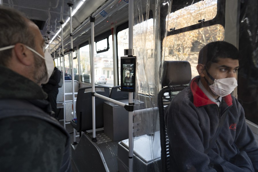 Un hombre verifica su temperatura corporal a través de una cámara termográfica instalada en un autobús de la línea 12 de la empresa de autobuses Transportes Automotores Callao S.A. durante un recorrido de prueba, en la ciudad de Buenos Aires, capital de Argentina, el 11 de junio de 2020. (Xinhua/Martín Zabala)