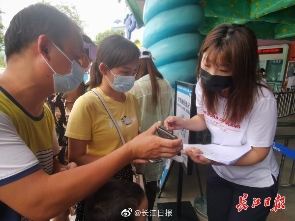 El personal ayuda a los turistas a registrarse en admisión. (Foto: Changjiang Daily)
