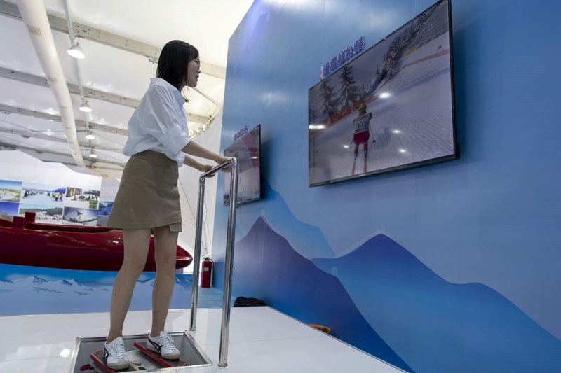 Una periodista prueba un simulador de esquí en el área de exhibición del Comité Organizador de los Juegos Olímpicos de Invierno de Beijing 2022, el 1 de septiembre. Por Weng Qiyu / vip.people.com.cn