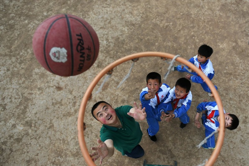 Wang Fengfeng juega al baloncesto con alumnos de la Escuela Primaria Nanqi. (Foto: Chen Bin/ Xinhua) 
