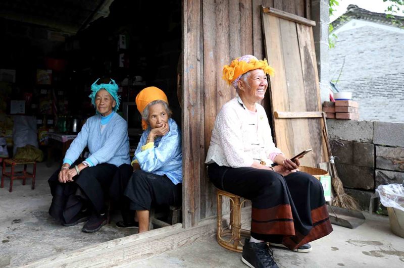 Nang Fenzhi (a la derecha) del grupo étnico Dai canta una canción popular como bienvenida para los visitantes de la aldea Palian, 27 de agosto del 2020. (Foto: Zhang Wei China Daily)