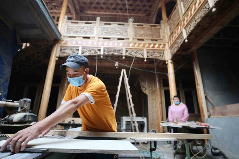 Los residentes de la aldea Xintaoshuhe, uno de las 198 puntos poblacionales pobres de Tengchong, trabajan en la renovación de viviendas, 18 de agosto del 2020. (Foto: Zhang Wei China Daily)