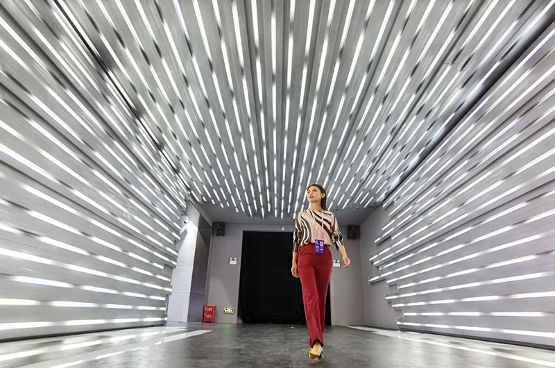 Una mujer pasa por un corredor futurista en la sala de exposiciones. Foto de Luo Jia