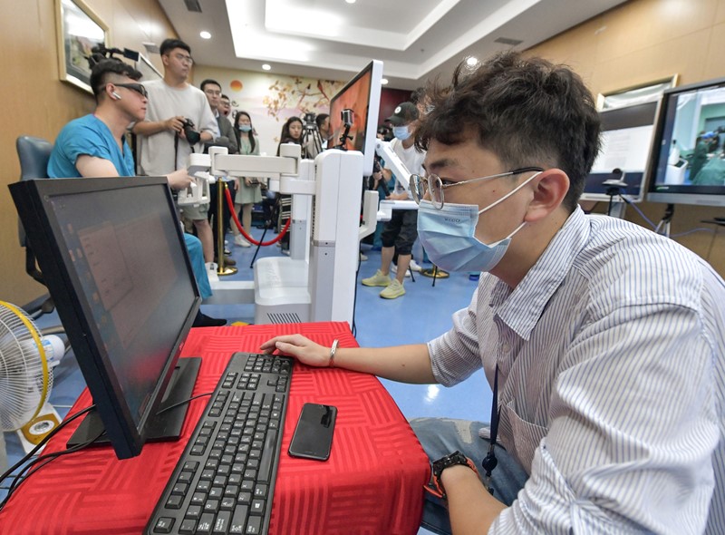 Un miembro del personal técnico comprueba la velocidad de Internet para que el doctor Niu Haitao, vicepresidente y profesor del Hospital Afiliado de la Universidad de Qingdao, lleve a cabo una operación remota con la ayuda de la tecnología 5G, Qingdao, provincia de Shandong, 24 de septiembre del 2020. [Foto: Xinhua]