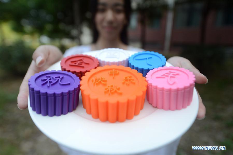 Una estudiante universitaria muestra modelos de pasteles de luna impresos en 3D para celebrar el próximo Festival del Medio Otoño en la Universidad de Yangzhou en Yangzhou, provincia de Jiangsu, en el este de China, el 12 de septiembre de 2016. Los chinos tienen la tradición de comer pasteles de luna en el Festival del Medio Otoño, que cae el 15 de septiembre de este año. (Xinhua / Meng Delong)