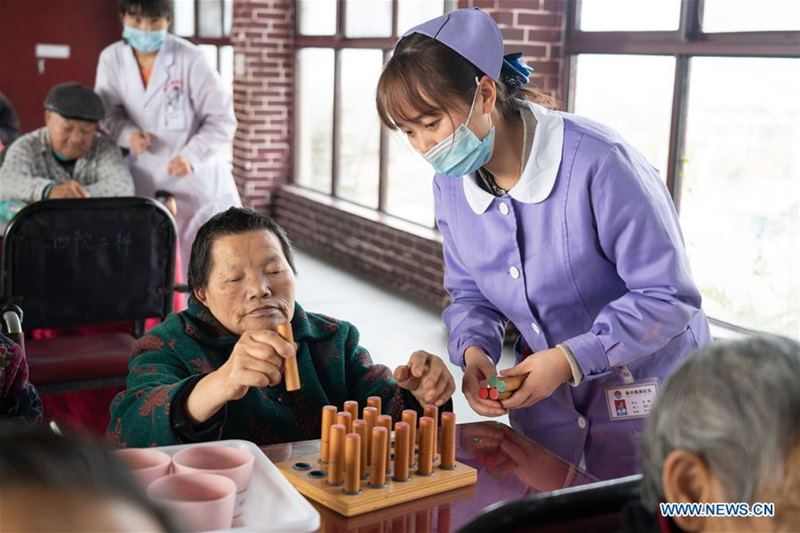Un trabajador de la salud ayuda a un anciano discapacitado en la residencia geriátrica del Hospital Longhui-Weiyuan, condado de Longhui, provincia de Hunan, 12 de octubre del 2020. Para elevar la calidad de la atención al adulto mayor, la unidad geriátrica proporciona servicios de enfermería, rehabilitación, entretenimiento y alimentación. (Fotos: Xinhua)