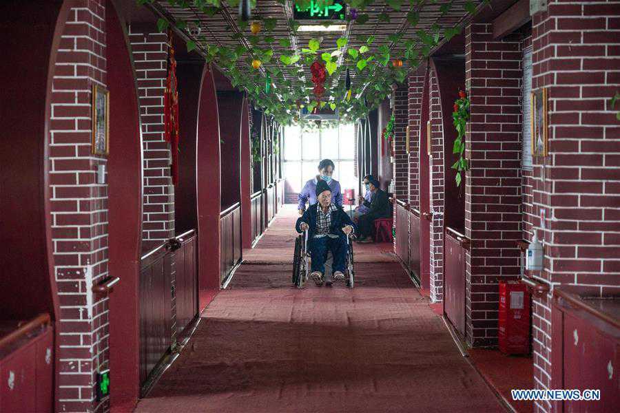 Un trabajador de la salud asiste a un anciano discapacitado en la residencia geriátrica del Hospital Longhui-Weiyuan, condado de Longhui, provincia de Hunan, 12 de octubre del 2020. Para elevar la calidad de la atención al adulto mayor, la unidad geriátrica proporciona servicios de enfermería, rehabilitación, entretenimiento y alimentación. (Fotos: Xinhua)