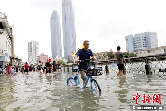 La imagen muestra a un ciudadano en bicicleta a través de una calle inundada de agua de mar. Foto de Li Siyuan, China News Agency.