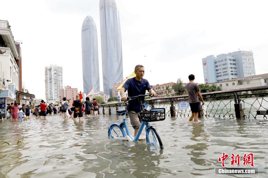 La imagen muestra a los ciudadanos en bicicleta a través de una calle inundada de agua de mar. Foto de  Li Siyuan, China News Agency.