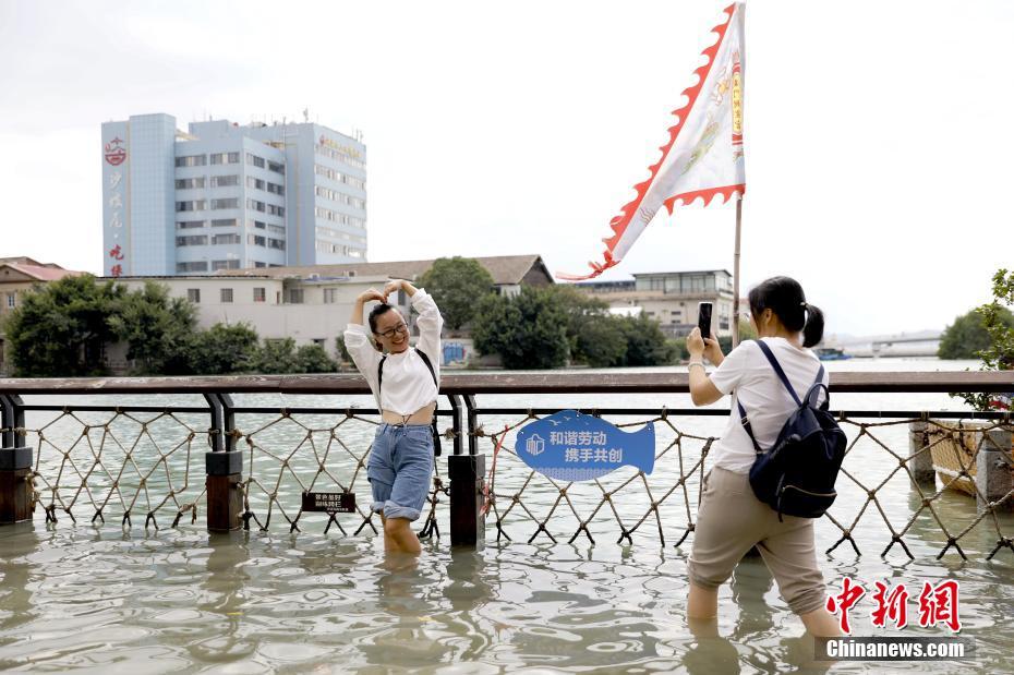 La imagen muestra a turistas haciéndose fotos en la zona inundada por la marea. Foto de  Li Siyuan, China News Agency.