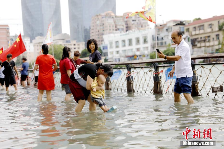 La imagen muestra a los ciudadanos divirtiéndose en el agua inundada por la marea. Foto de  Li Siyuan, China News Agency.