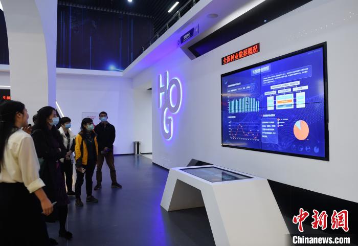 La imagen muestra a los visitantes en el primer gran centro de datos de la industria porcina a nivel nacional de China, donde conocen la conveniencia que brindan las aplicaciones inteligentes para la cría de cerdos. Foto por Zhou Yi