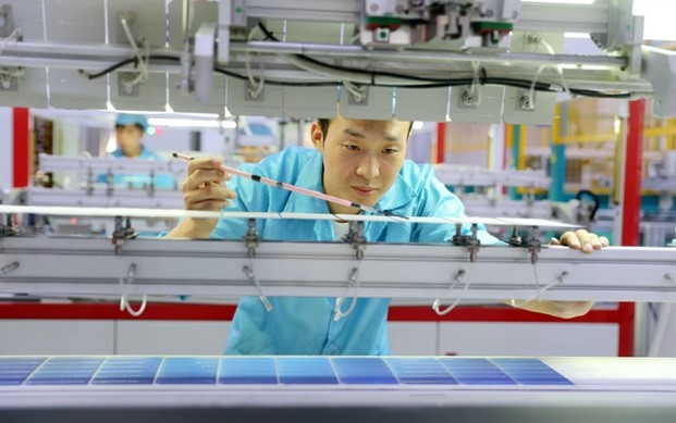 Un trabajador conecta e inspecciona los componentes de las células solares en un taller de una nueva compañía de energía en Huzhou, provincia de Zhejiang, en el este de China, el 9 de octubre. Foto de Wang Shucheng / Pueblo en Línea