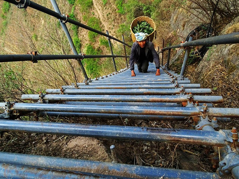 Un aldeano regresa a la "aldea del acantilado" a través de las escaleras de acero recién construidas, 5 de mayo de 2020. (Foto: Lao Bing/ Pueblo en Línea)