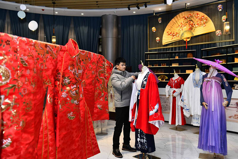 Hu Chunqing organiza trajes para presentarlos en su estudio de Caoxian, provincia de Shandong, 11 de diciembre del 2020. [Foto: Xinhua]